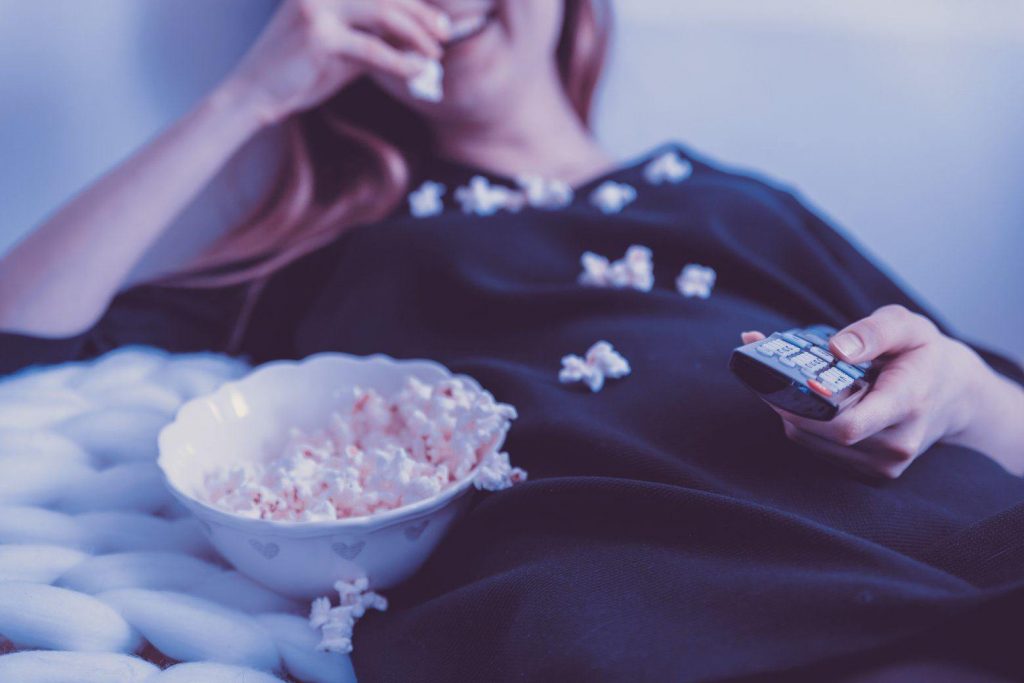 woman on sofa eating popcorn