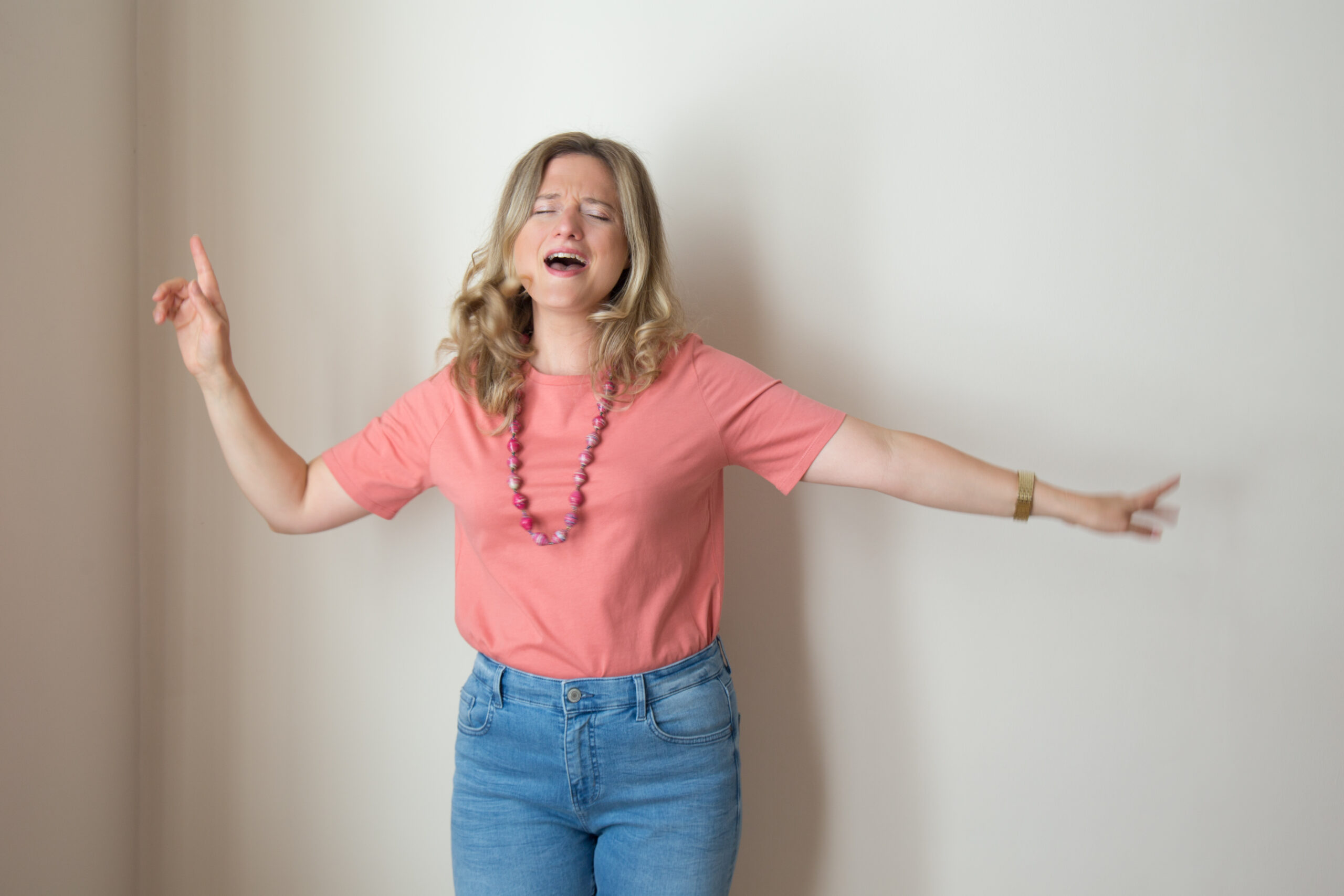 Woman holding her arms out in a dance pass, singing or chanting.